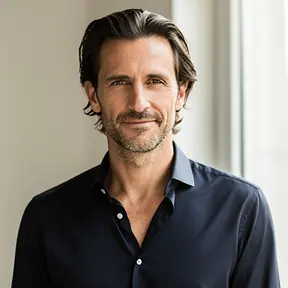Portrait of a French man in his early 40s, natural indoor light, minimal background, authentic editorial style, confident and relaxed expression, high resolution
